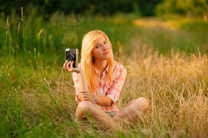 girl holding vintage camera outdoors